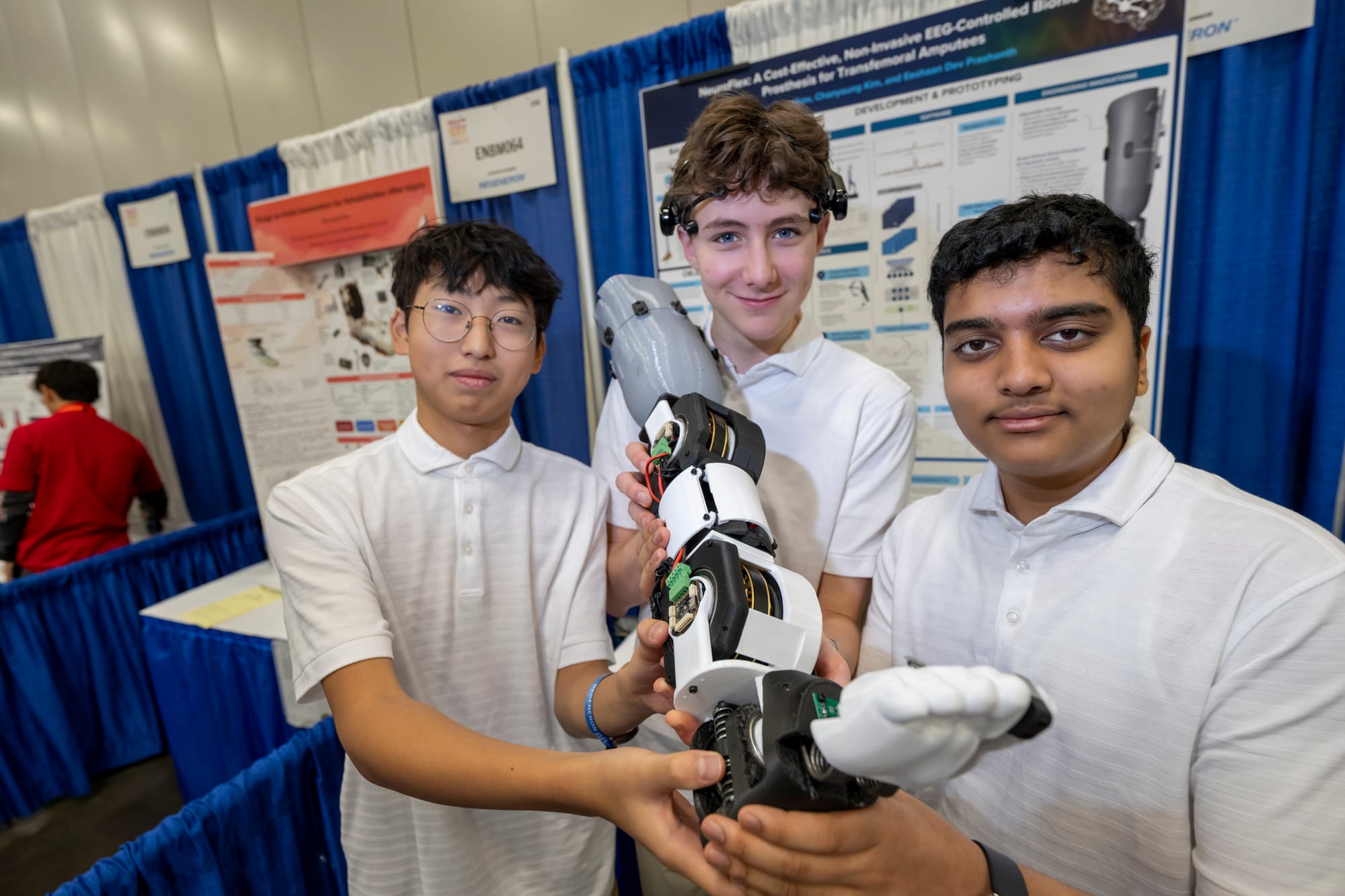 3 boys holding a prosthetic leg