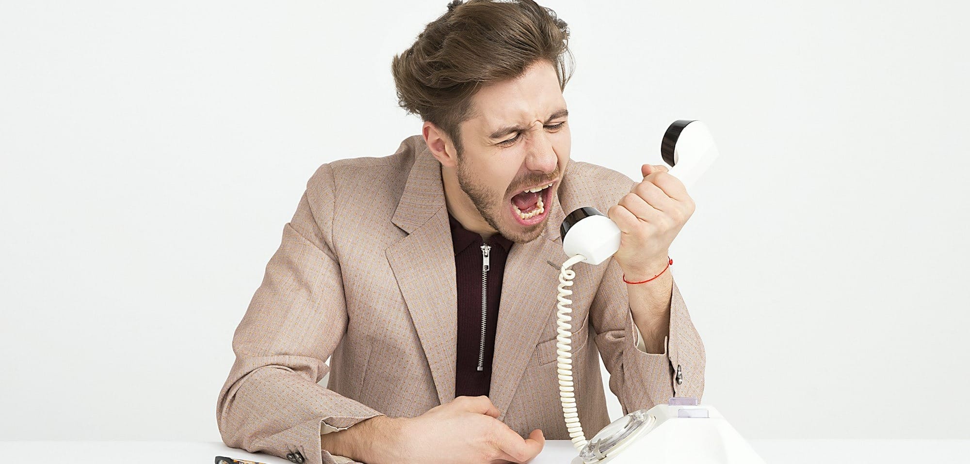 man holding telephone screaming