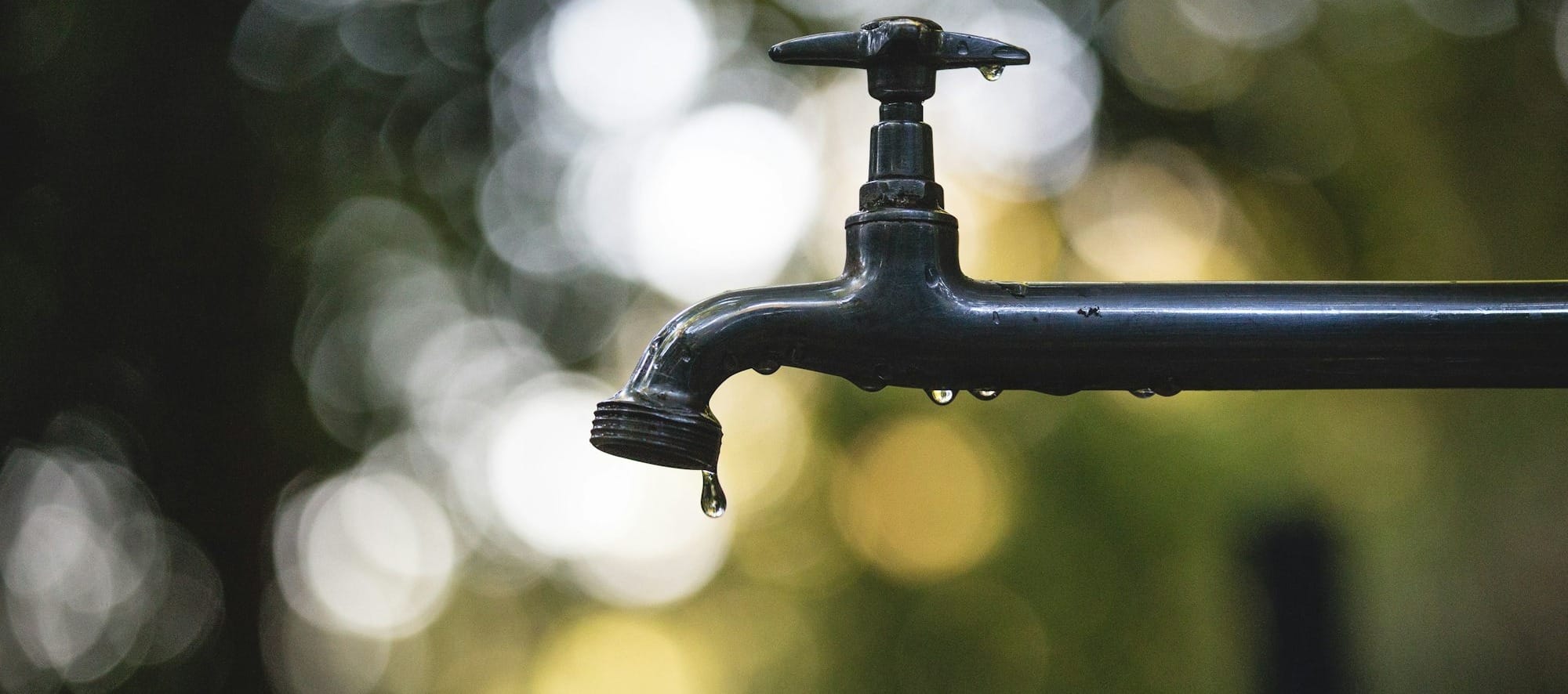 tilt shift lens photography of black steel faucet